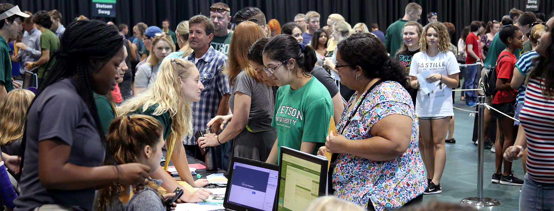 A line of students and their parents wait in the Rinker Field House on Move-in Day.