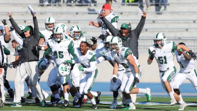The players and coaches erupt into cheers on the sidelines after the trick play lifted them over Drake University