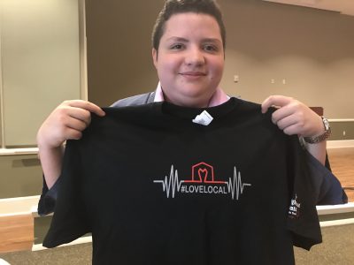 Gabriel Trevino holds up a t-shirt with the winning design