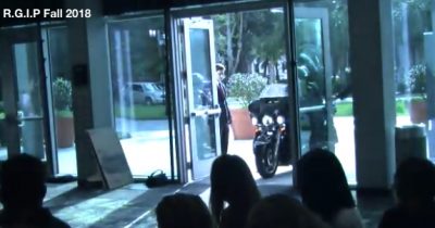 Screenshot of double doors open Harley pulling up just outside