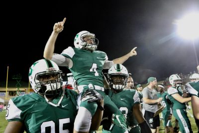 Two Hatter players carry Jonny Messina on their shoulders as they celebrate the win on the field