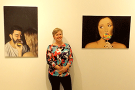 Tonya Curran stands in between two pictures on the museum wall.