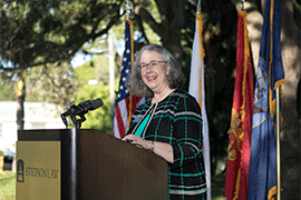 Wendy Libby at the lectern, printed with Stetson Law and U.S., and Florida state flags behind her.
