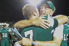 Coach Roger Hughes hugs quarterback Colin McGovern after their 38-35 win at home over Jacksonville University on Oct. 20.