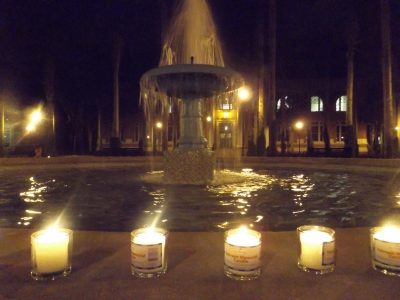 small lighted candles circle the Holler Fountain