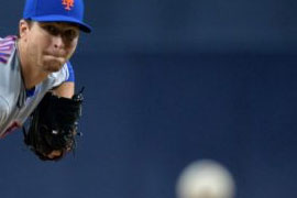 He throws a pitch and the ball is coming toward the camera