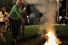 woman throws a sprig on the fire