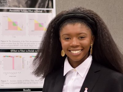 portrait in front of an academic display board with charts, etc.