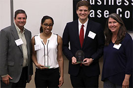 Two students stand holding award with two donor/sponsors