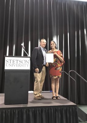 Professor holds the proclamation and stands beside the mayor