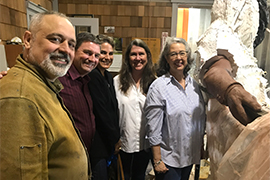 Group shot of the five of them with the sculpture, mostly covered in ceramic mold, beside them