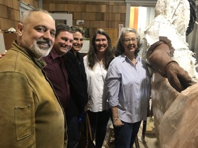 Group shot of the five of them with the sculpture, partially covered in the mold, beside them