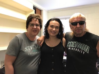 Student poses with her parents in residence hall room
