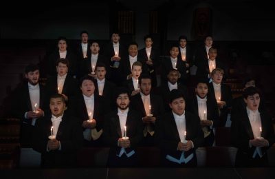 group photo of the men in Stetson's Concert Choir singing and holding with candles