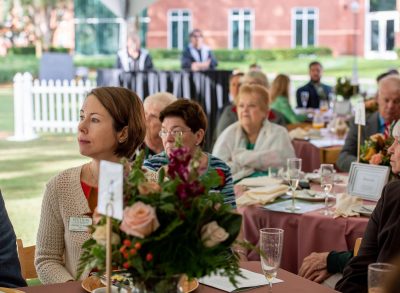 among the crowd seated at tables, she listens