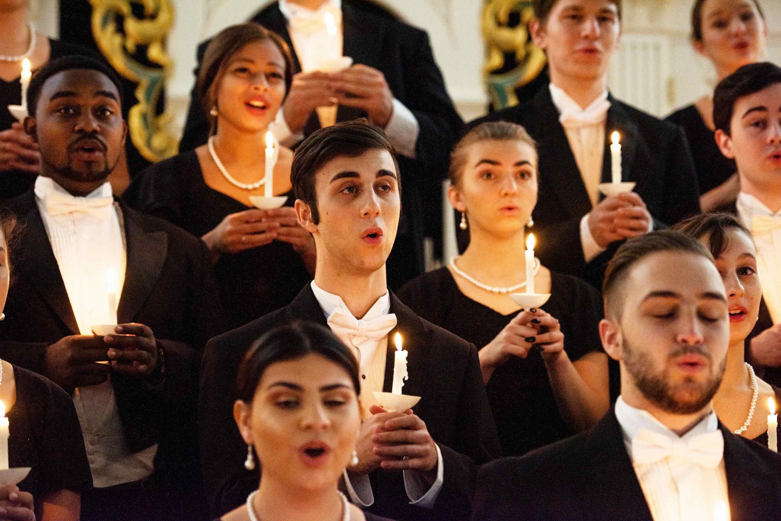 A choir performing holding candlelights
