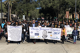 A crowd of marchers on Woodland Blvd. holding MLK banners during march