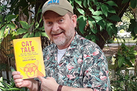 author holds his newest book, outside