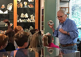 Dr. Sam Upchurch holds up piece of agatized coral to show school kids