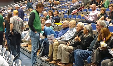 Gus Gibbs sits in the stands at a basketball game