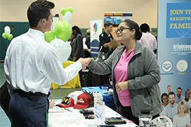 A student shakes hand with a job recruiter at a job fair