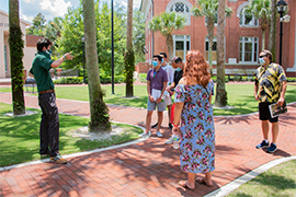 A Stetson tour guide leads a small group on a tour, all of them wearing face coverings