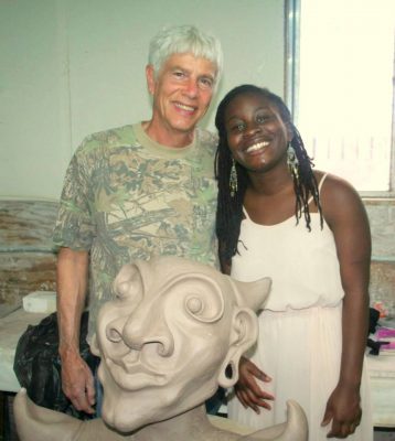 the two pose for a portrait with clay artwork