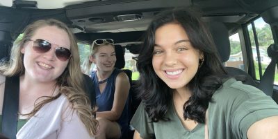The three students talk a selfie in a car