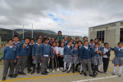 Rajni Shankar Brown stands amid a group of young schoolchildren.