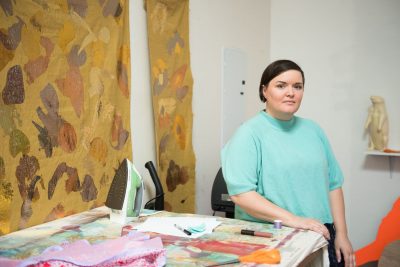 Portrait with fabric and other artistic materials around her