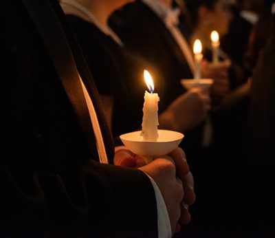 A closeup of choir members holding candles