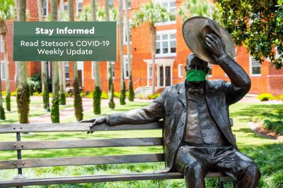 John B. Stetson statue wears a face covering.