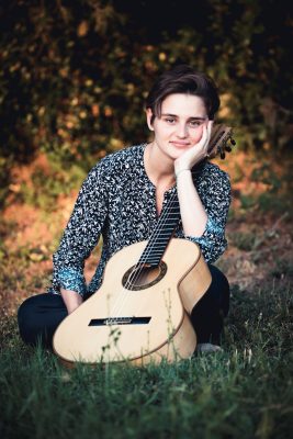 portrait outside with a guitar