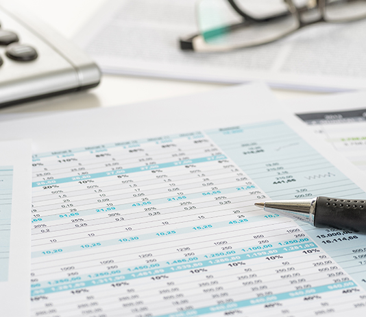 a spreadsheet with a pencil, calculator and glasses.