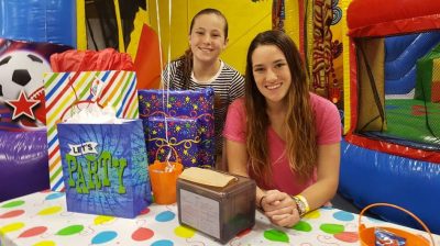 Student sits with birthday party items.