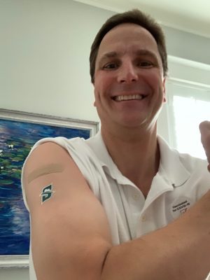 portrait with bandaid on his arm from vaccine and Stetson temporary tattoo.