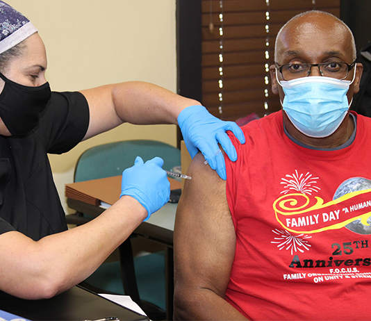 Law professor gets a vaccination from a nurse.