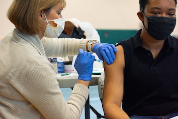 students gets a shot from a nurse