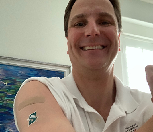 portrait with bandaid on his arm from vaccine and Stetson temporary tattoo.