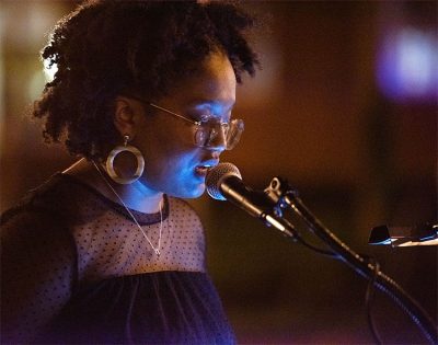 Tahira Perry speaks into a microphone at the vigil.