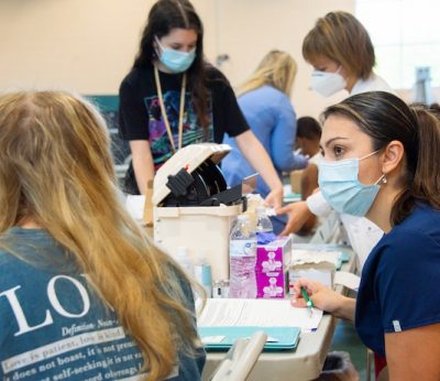 Johana Burgos, director, Stetson Health Service, works at the vaccination event on campus