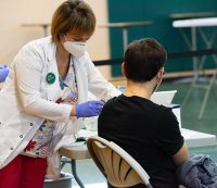 A student gets a vaccine in the Rinker Field House