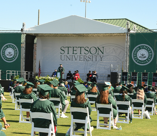 Graduates gather on the field for Commencement 2021.