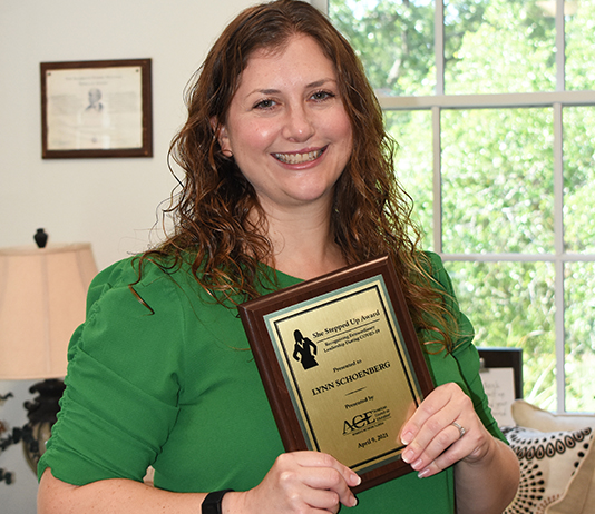 Lynn Schoenberg holds her award.