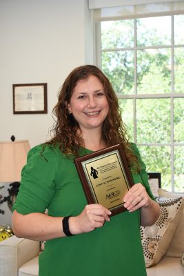 Lynn Schoenberg holds her award.