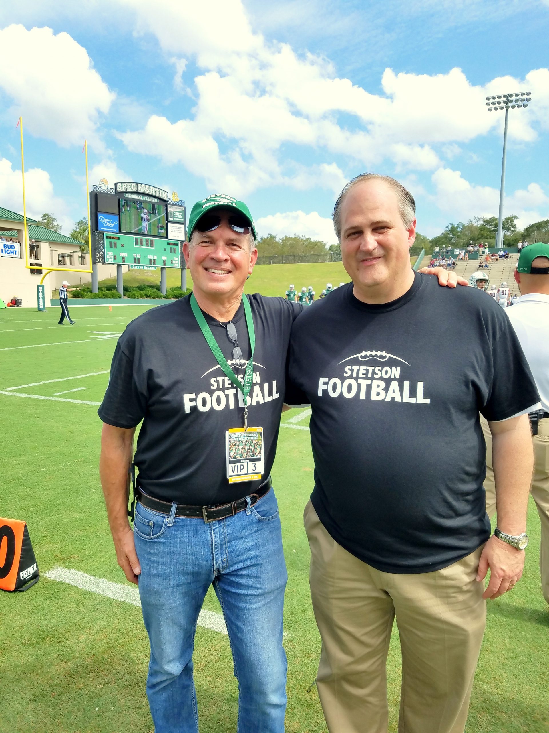 Scott Boore and Ray Holley pose on the field at a Hatters football game