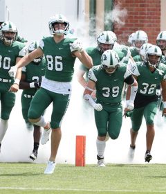 The Hatters football team runs onto the field.
