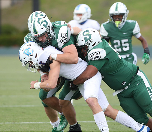 Hatter players make a tackle on the field