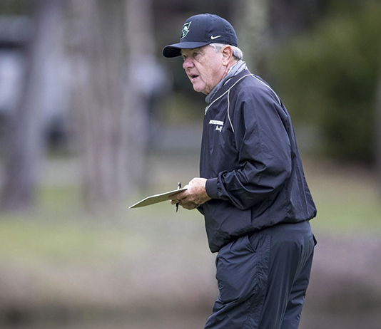 portrait on a golf course with clipboard in his hand