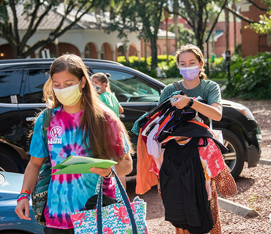 Students carry their belongings into residence halls